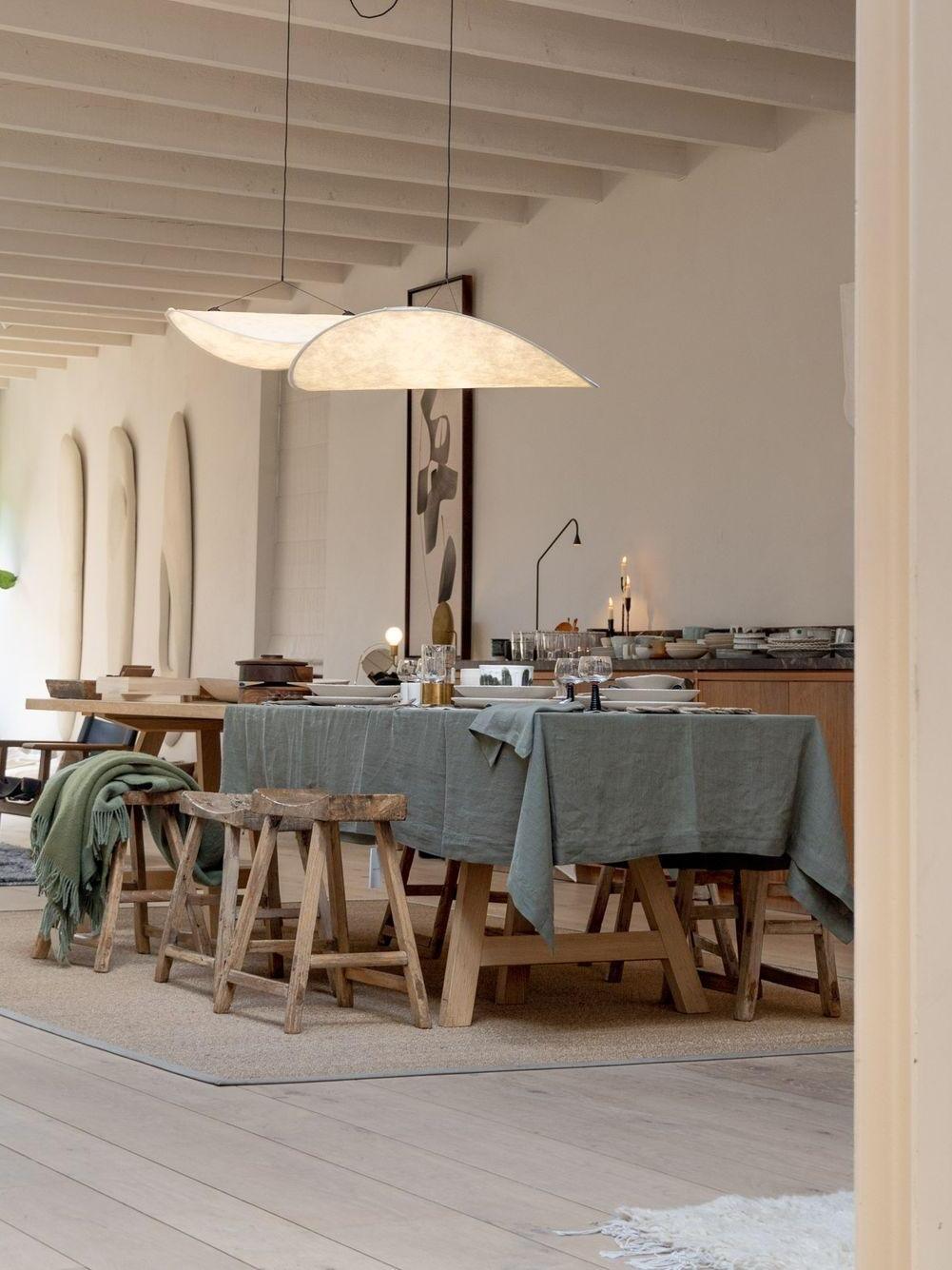 Pair of illuminated shades over a long dining table