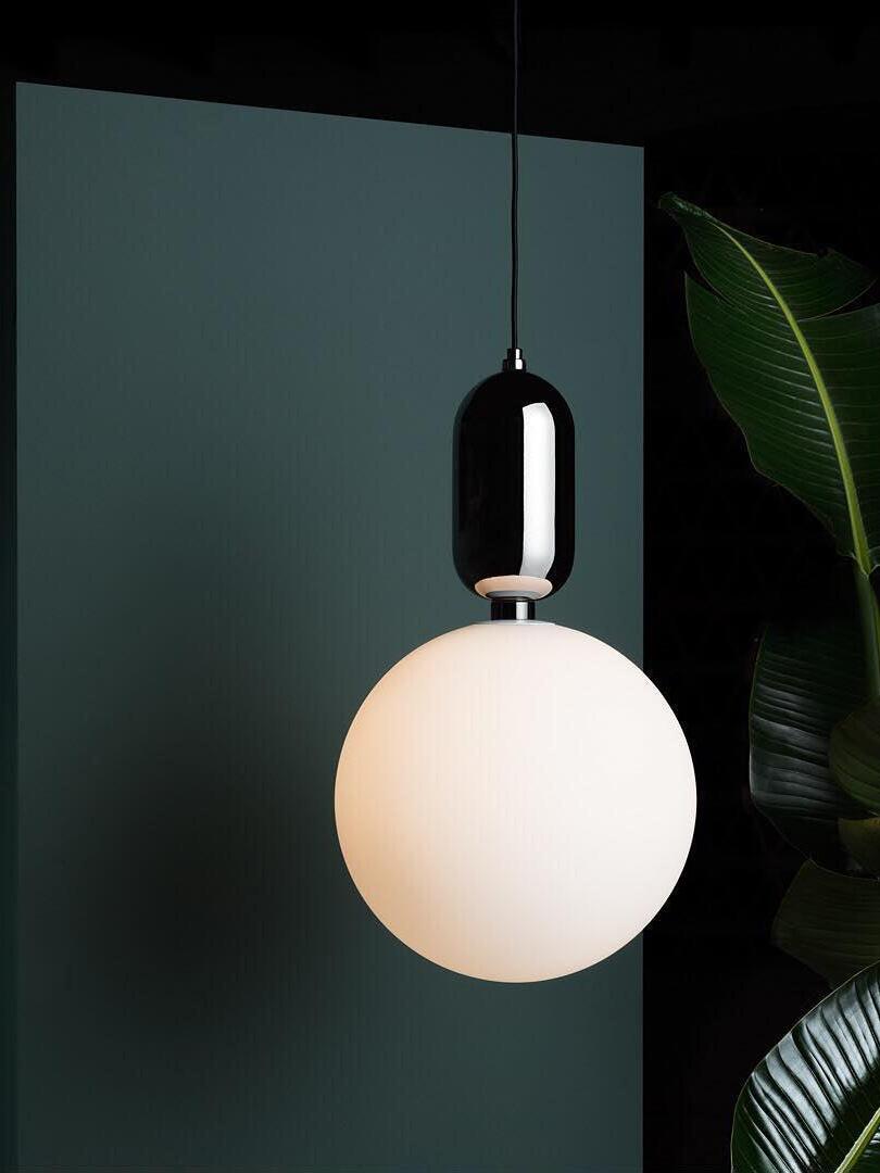 Lit white globe and black cap against a dark green wall
