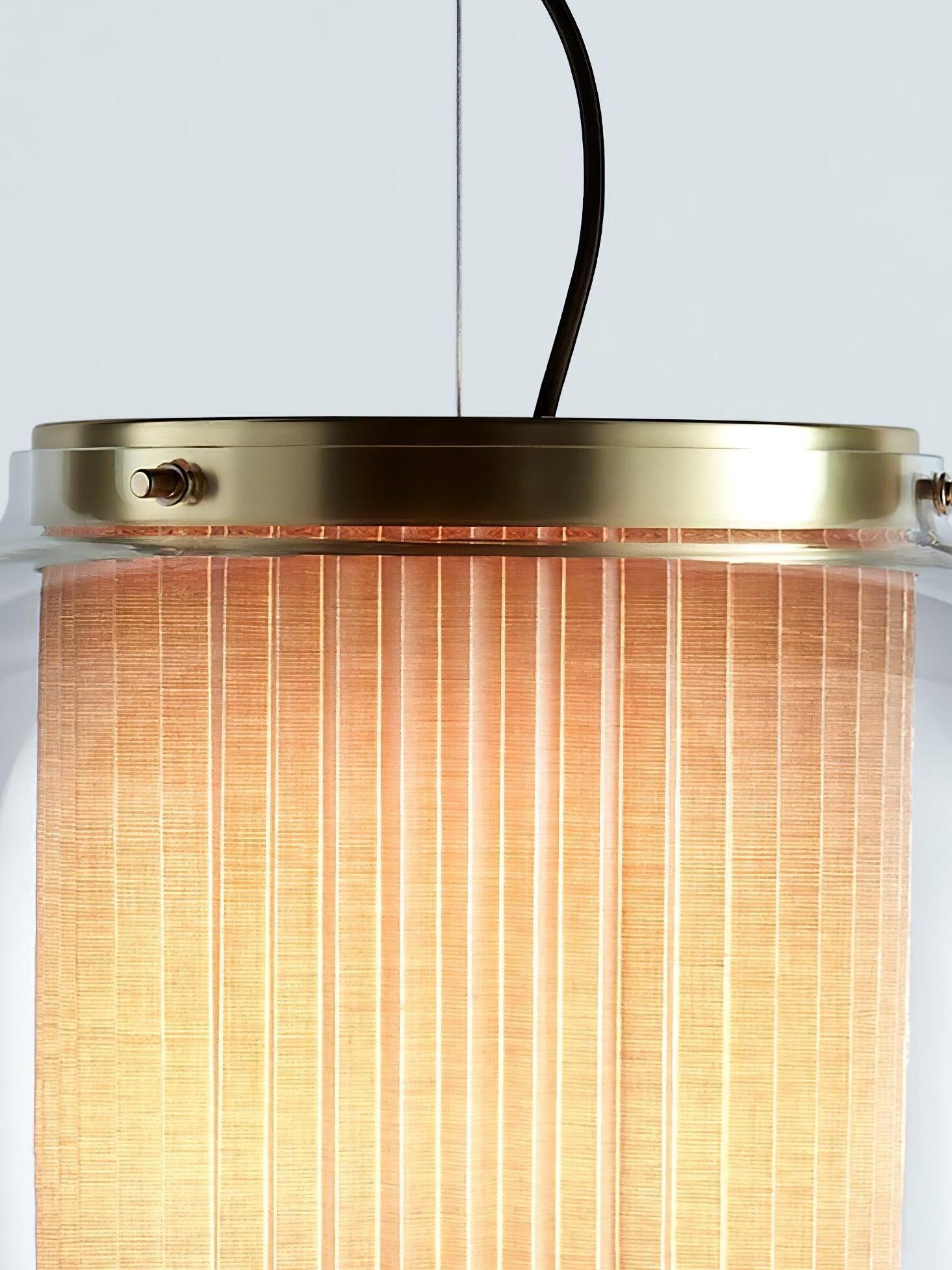 Close-up of the Gold Manila T upper rim, side fasteners, clear glass edge and lit vertical fabric folds