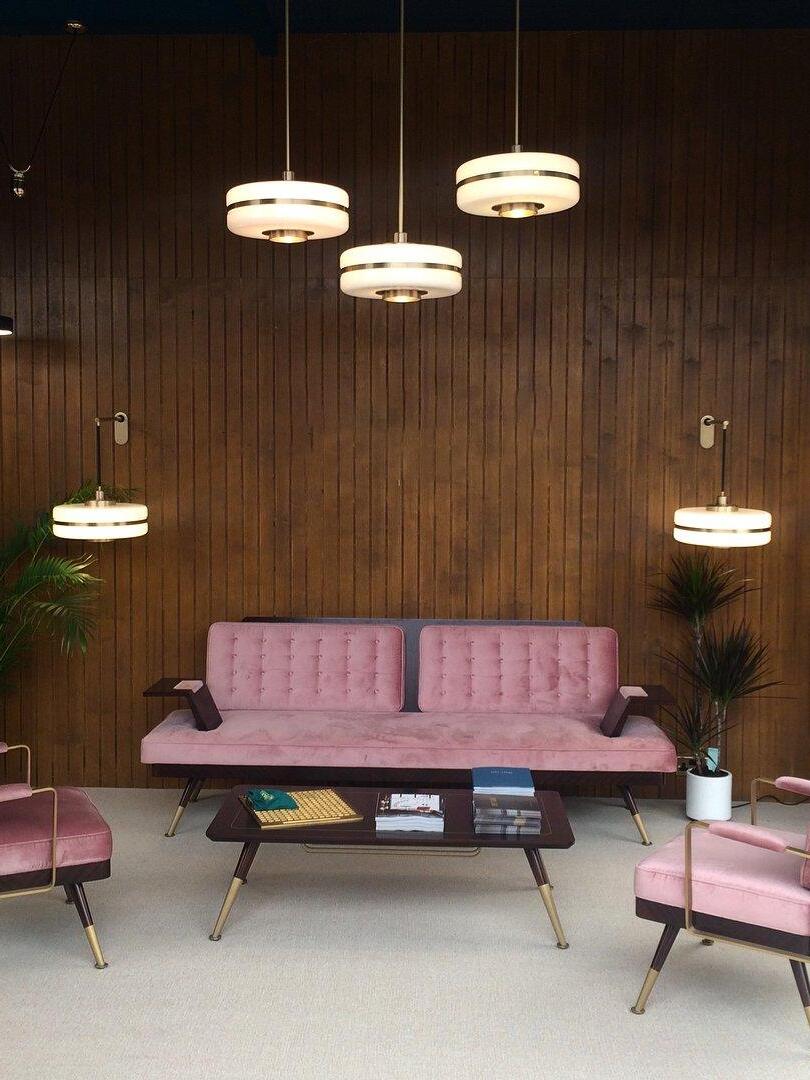 Grouped opal-glass pendants in a living area with pink seating