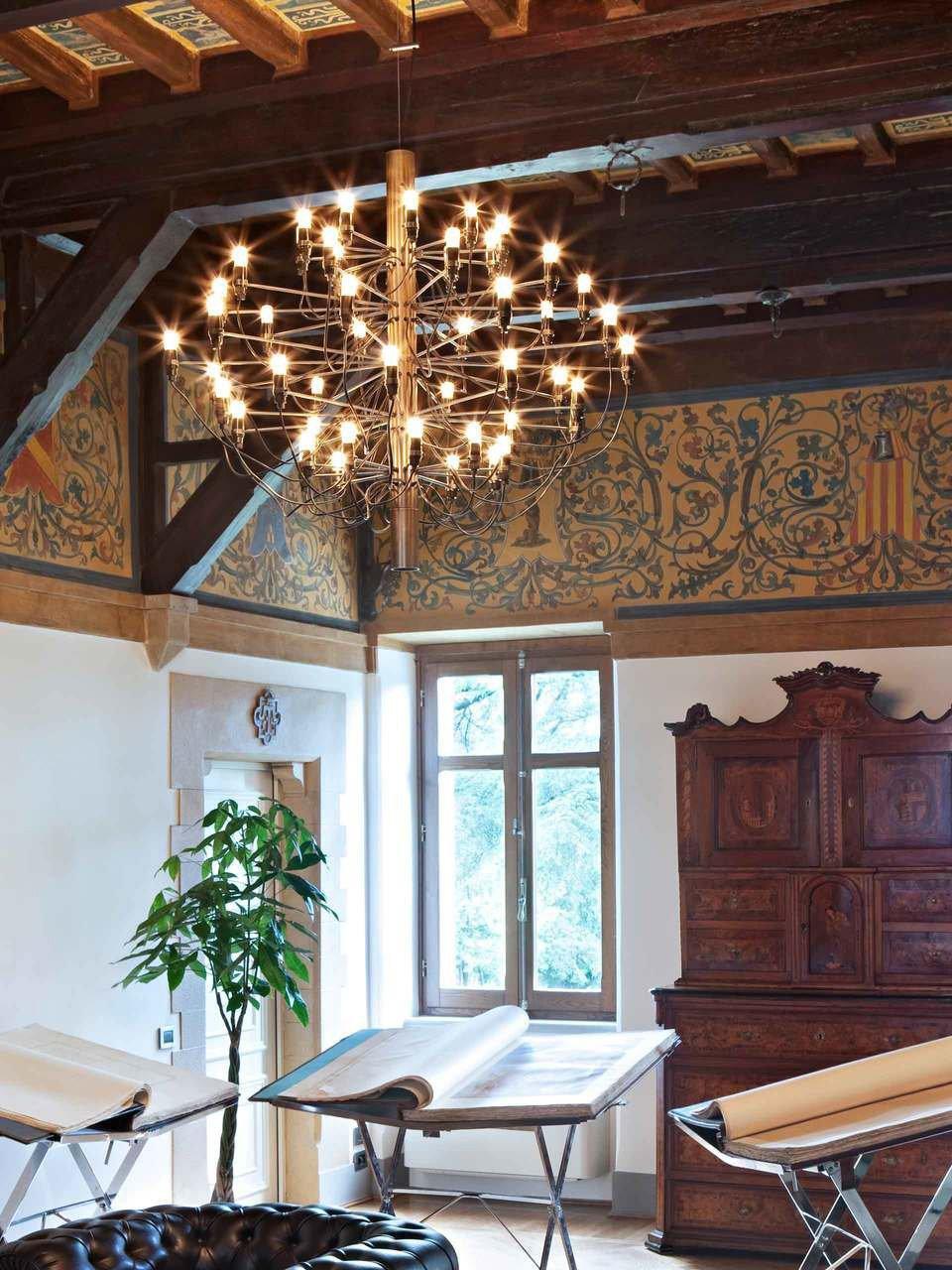 Illuminated chandelier under exposed ceiling beams