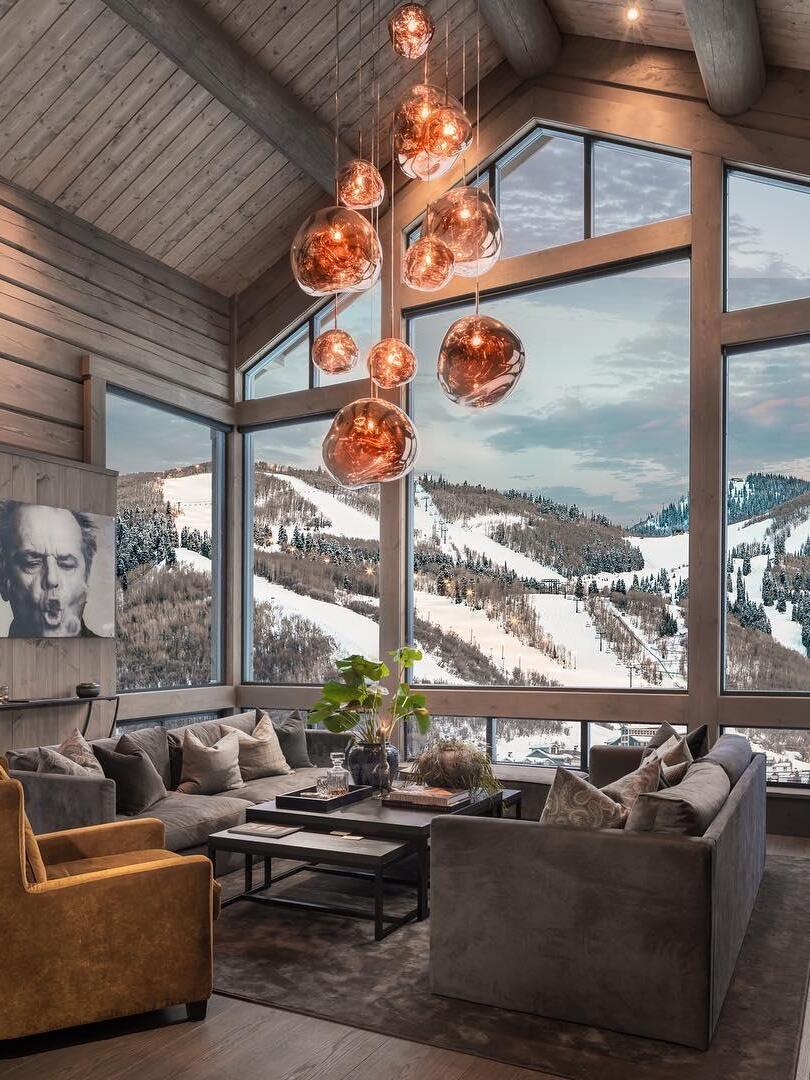 Grouped reflective pendants in a tall lounge