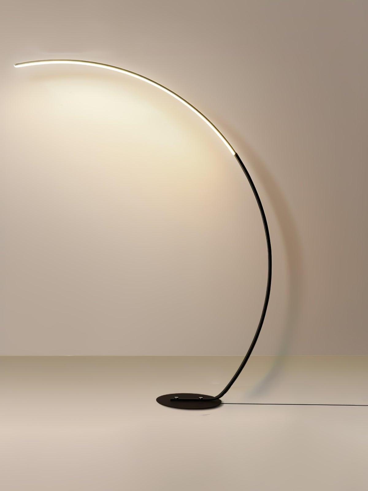 Black arc LED floor lamp on pale background