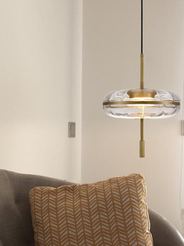 Glass pendant beside a sofa with patterned cushion