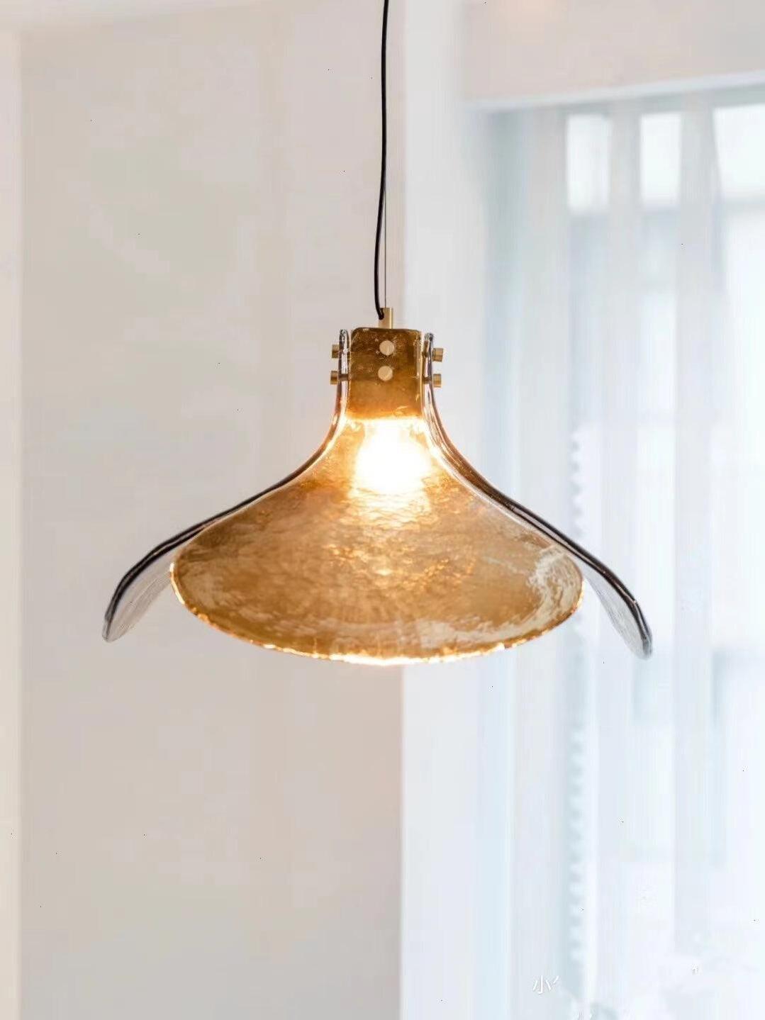 Flared glass pendant hanging beside a bright window