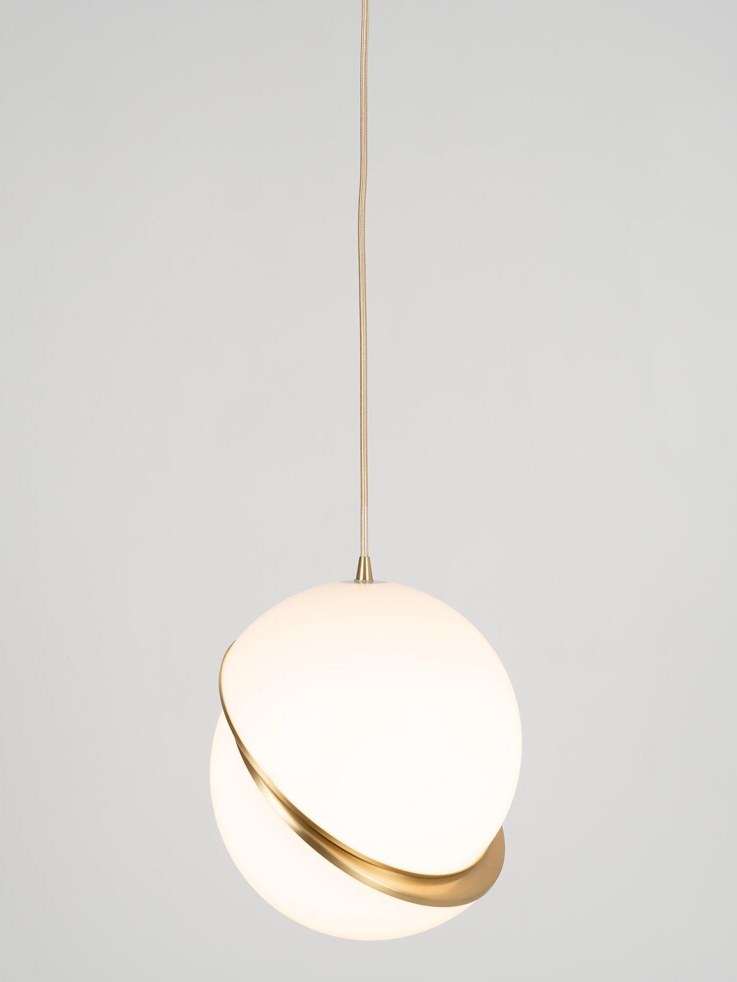 Single illuminated Crescent white globe with a curved gold-colour band and textured hanging cord against grey