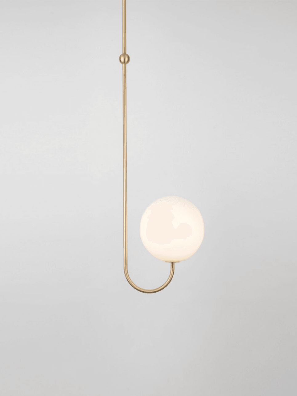 Single opal globe on an upward-curved brass arm beside a slim suspension stem