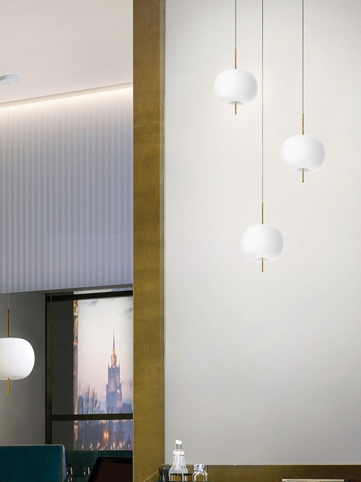 Three white rounded pendants hanging at varied heights