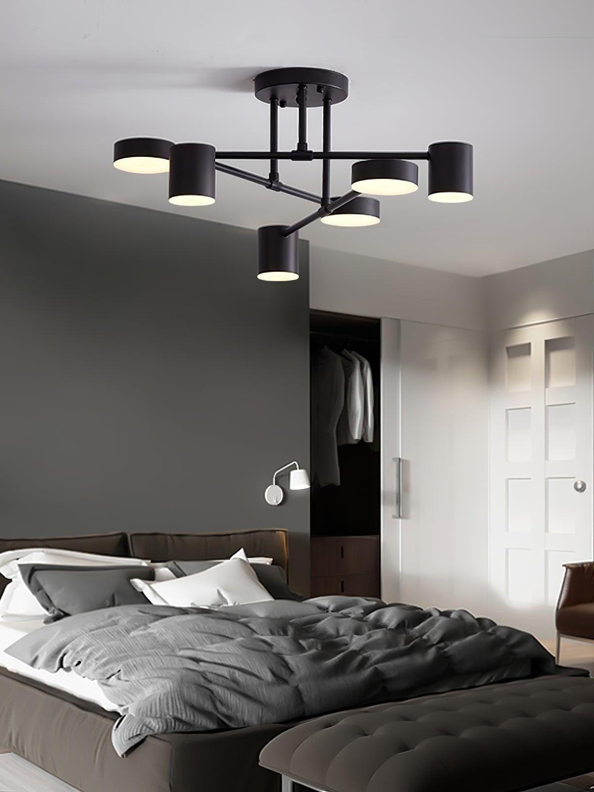 Black six-head ceiling light with warm-looking round faces above a gray bed beside an open wardrobe