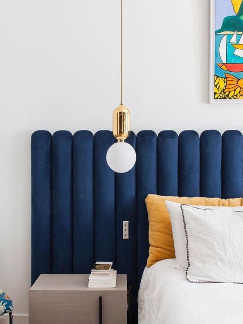 Small globe pendant beside a blue headboard