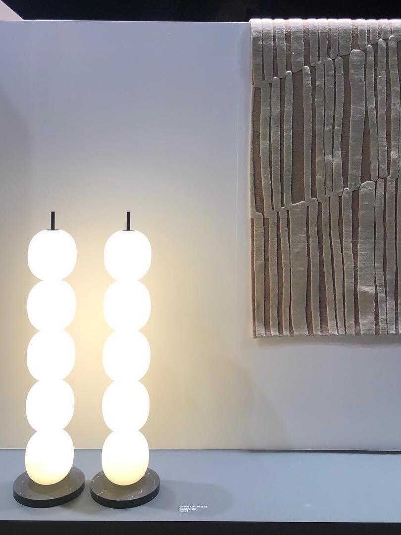 Two illuminated stacked-globe lamps in display