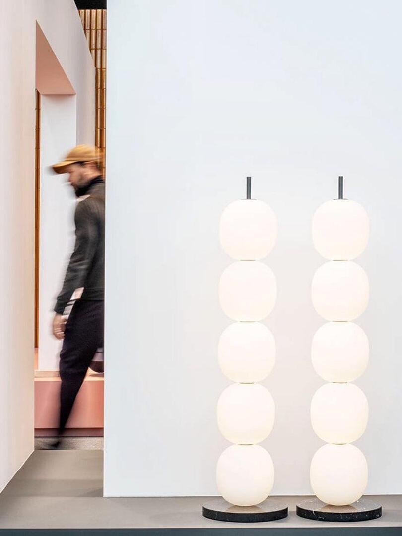 Two globe lamps in display with a passerby