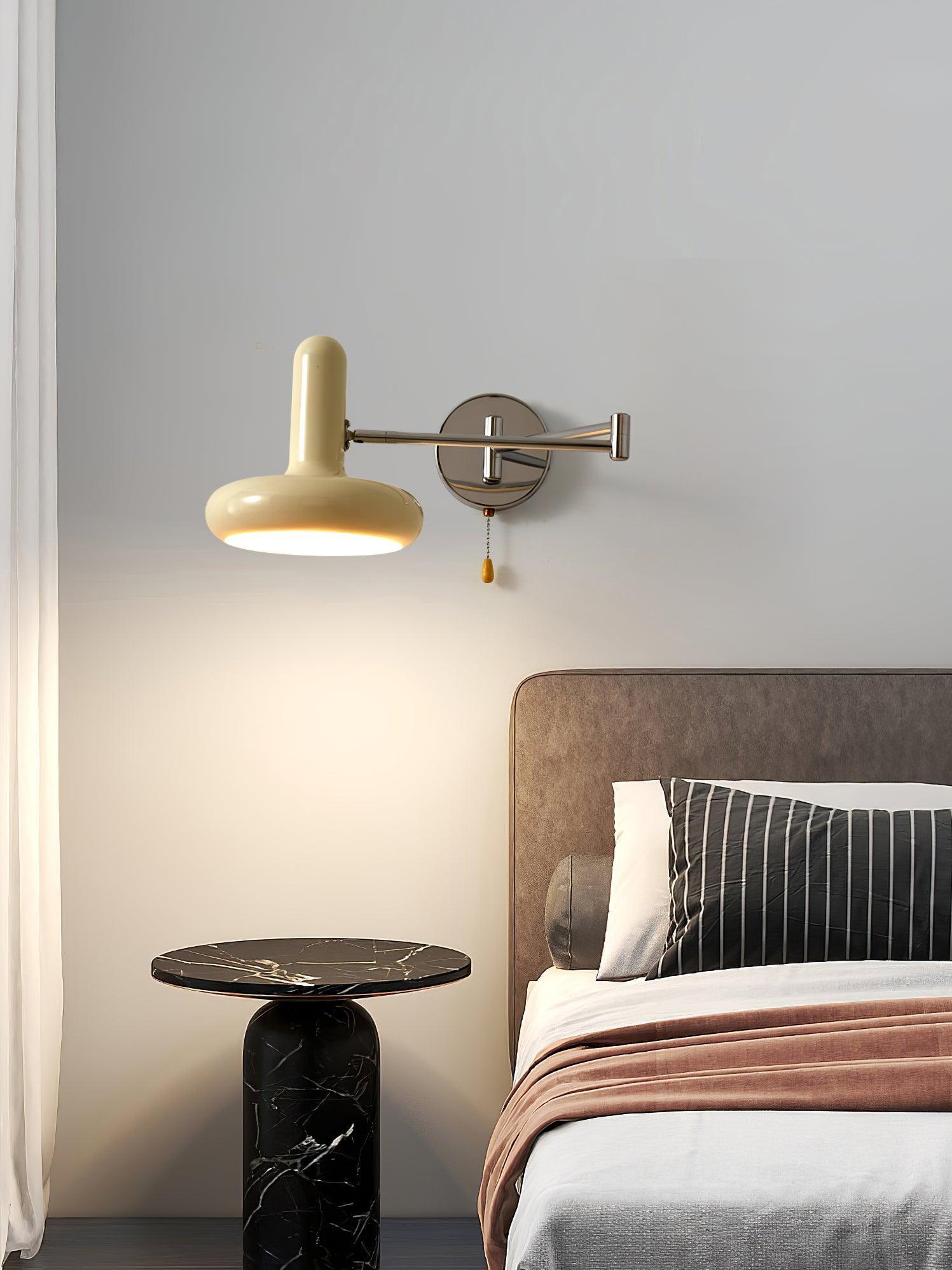 Lit cream disc wall lamp beside bed
