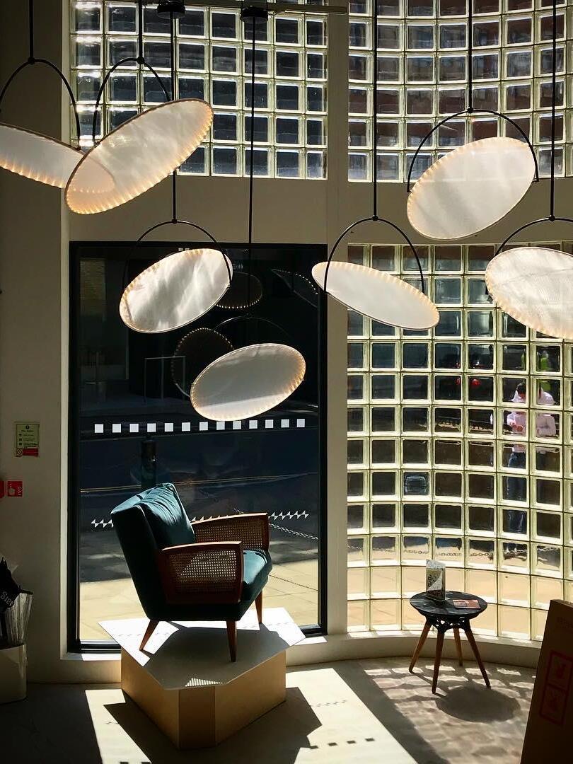 Group of angled disc pendants in a tall interior