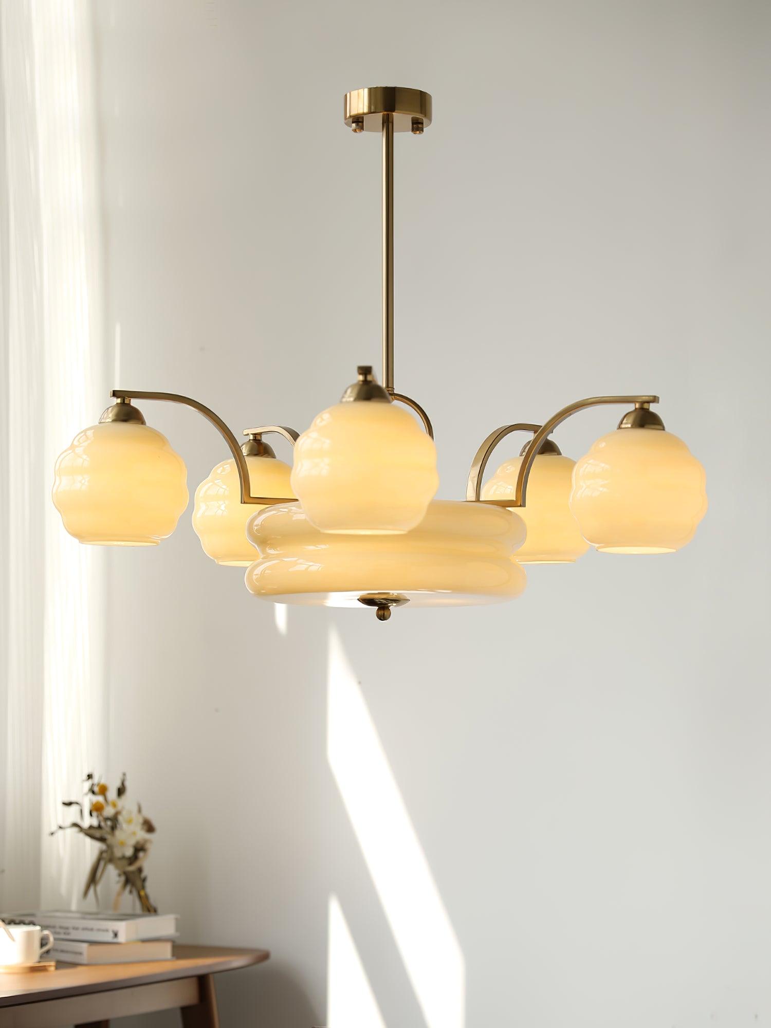 Gold finish chandelier glowing beside a window