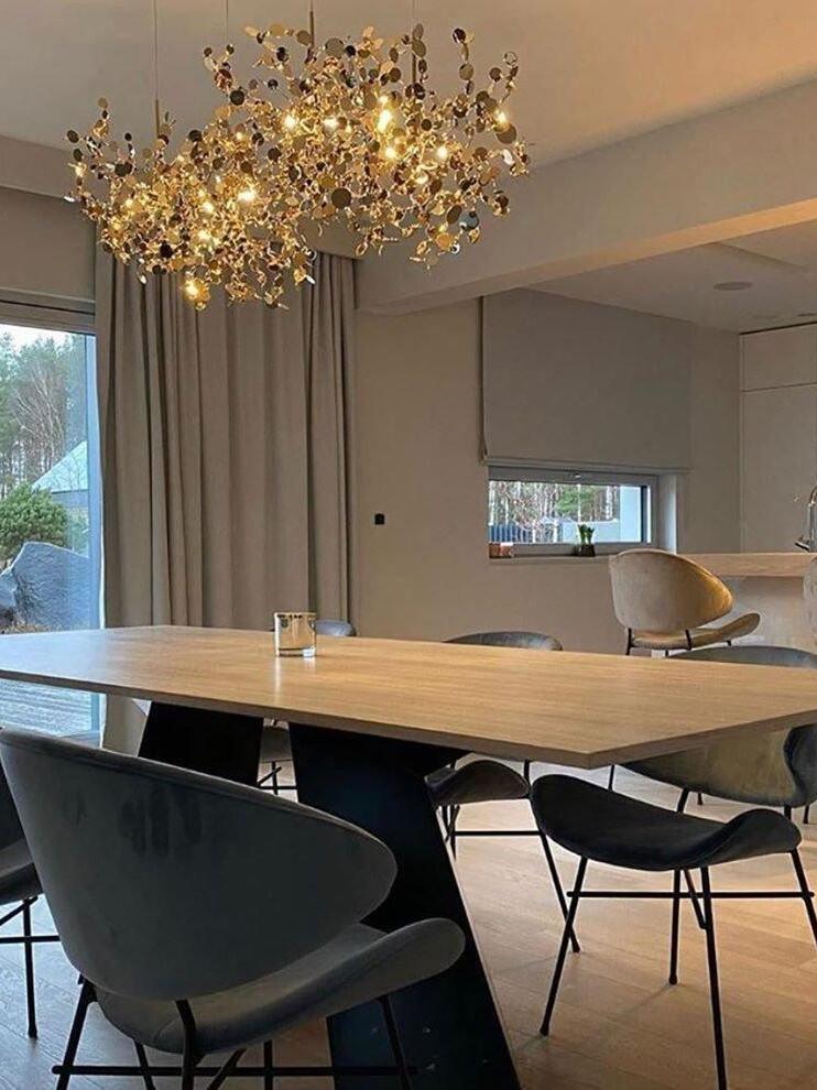 Gold disc chandelier above a pale dining table