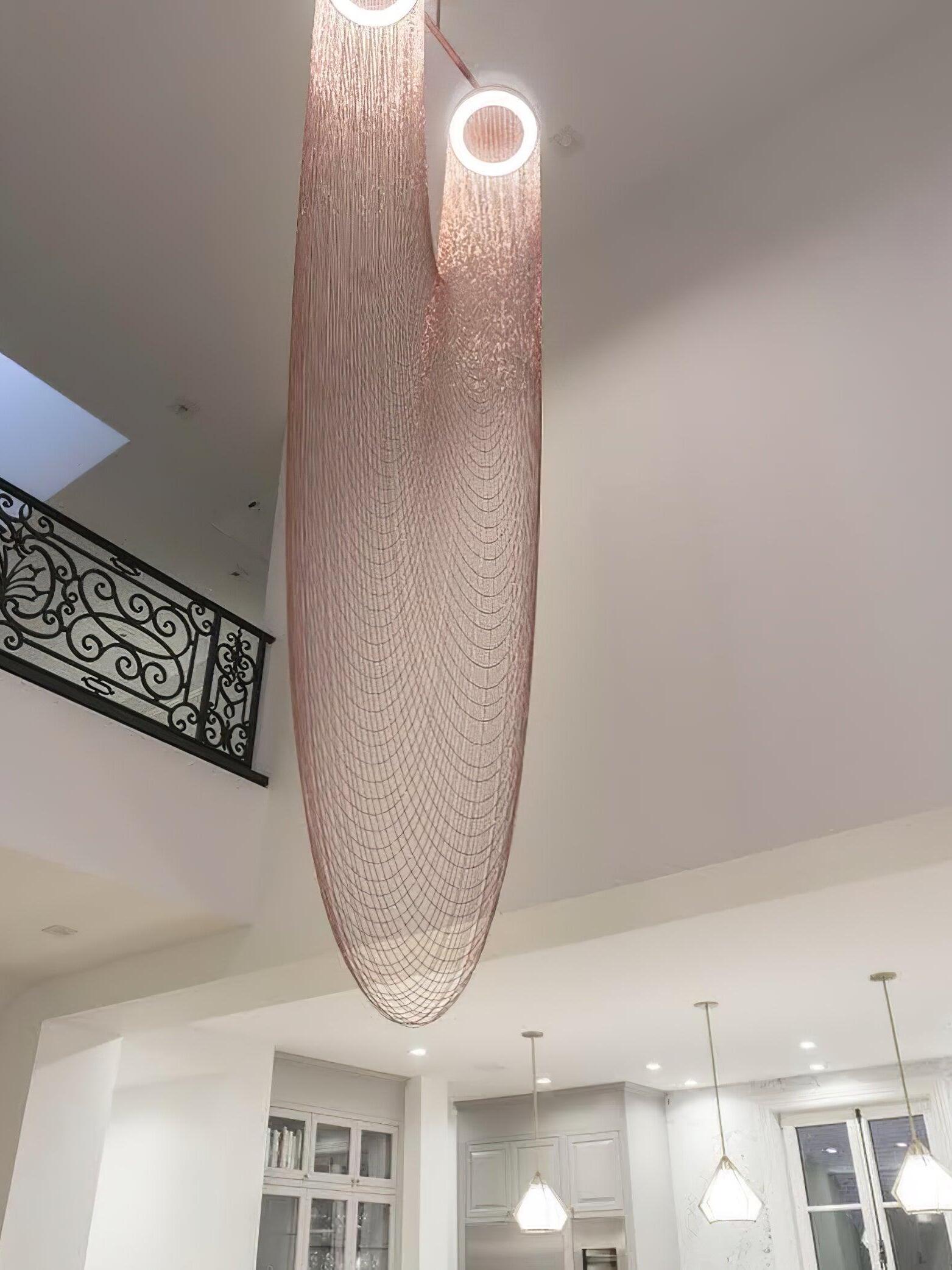Long rose-gold chain fixture in a high-ceiling interior