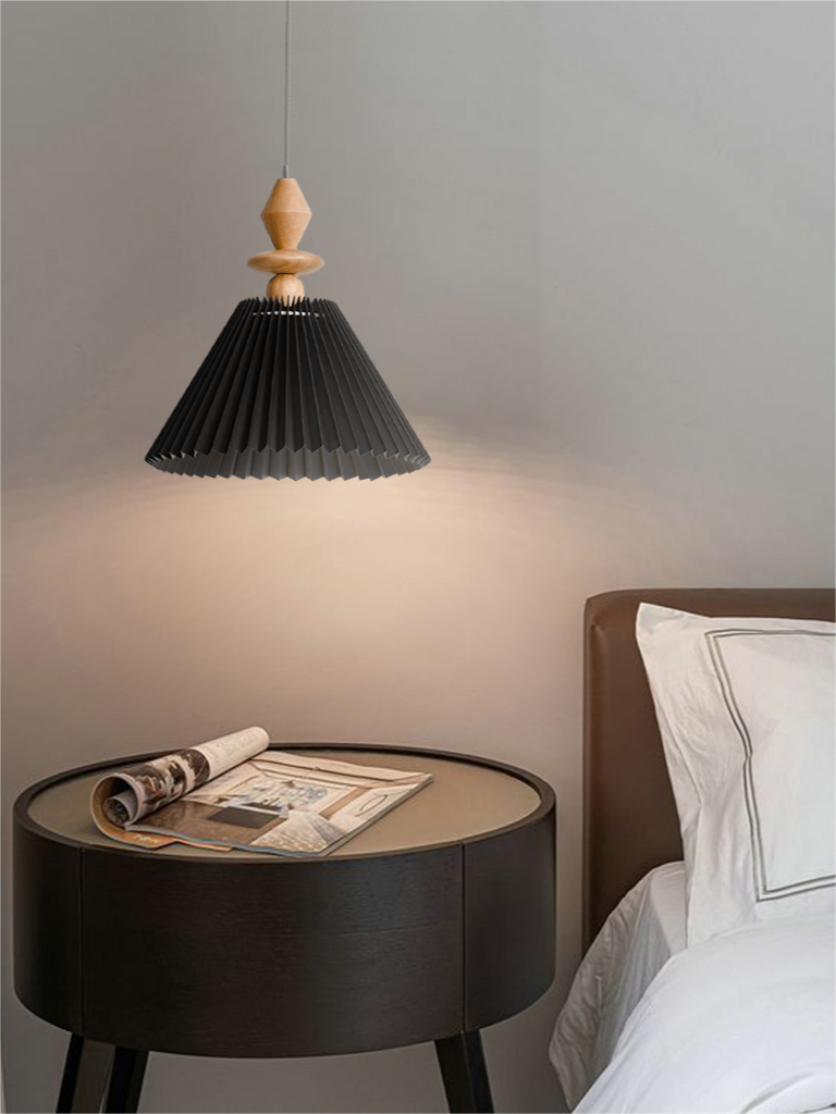 Black Takumi pendant with a pointed wood finial beside a bed