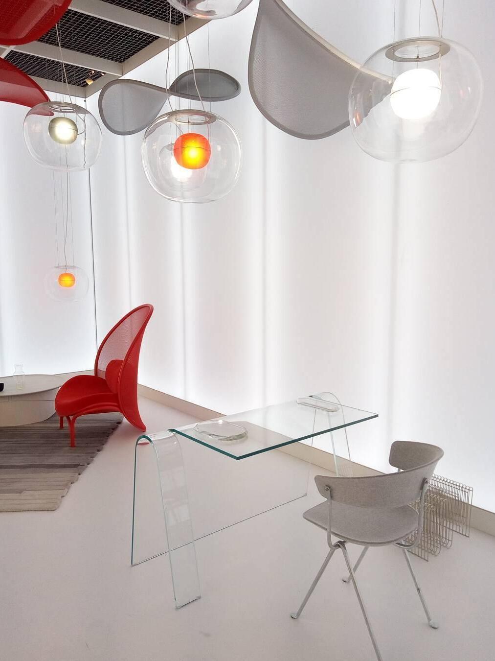 Globe pendants above a glass table in a bright display room