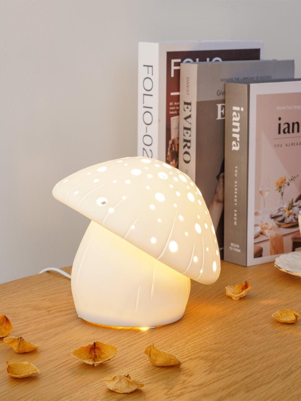 Angled view of the lit tilted mushroom cap beside books on a wooden table
