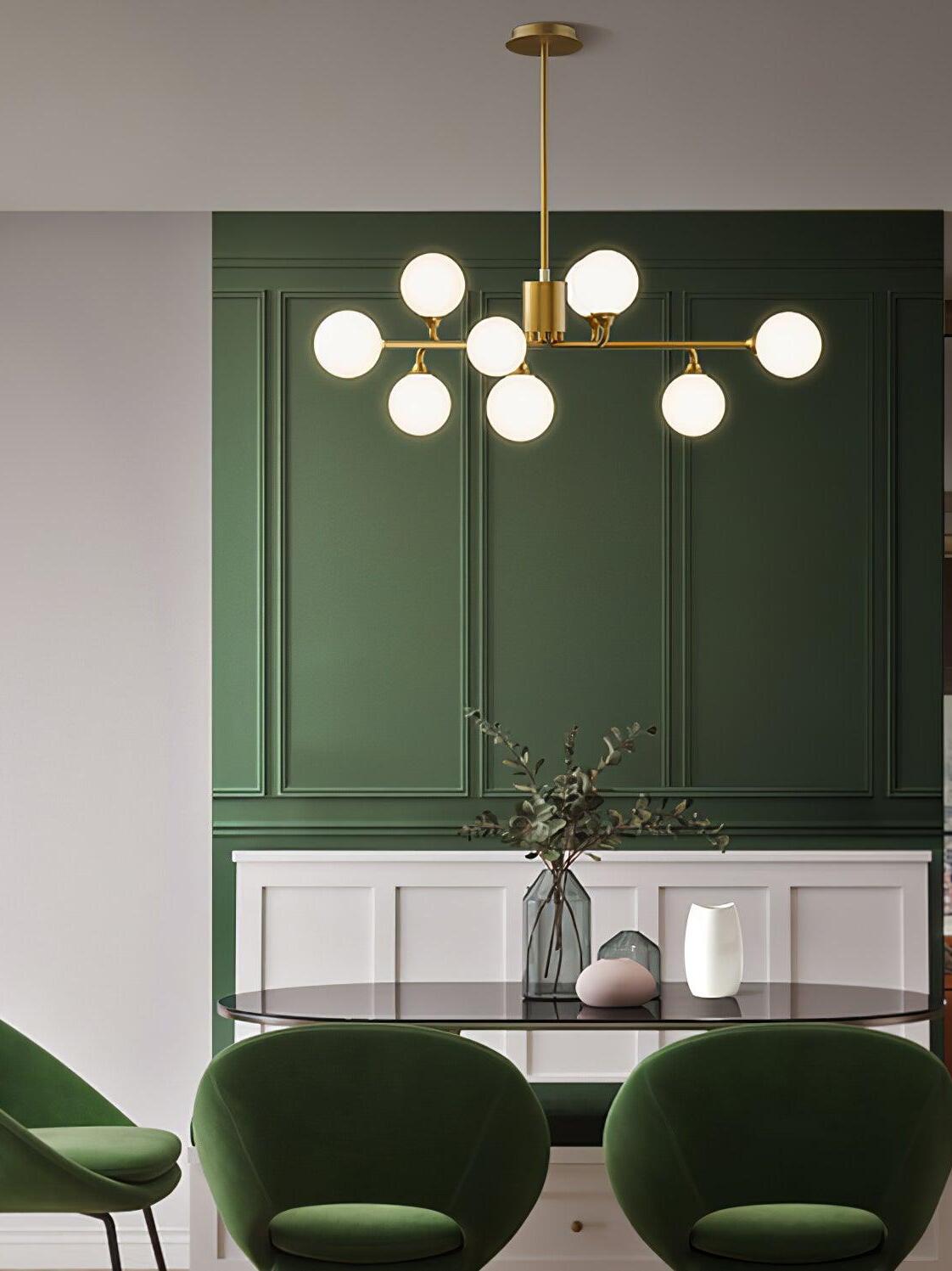 Multi-globe brass chandelier in green-walled room