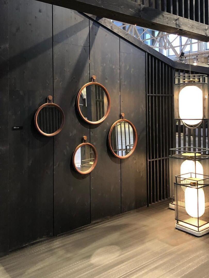 Black hanging and standing lanterns before circular mirrors