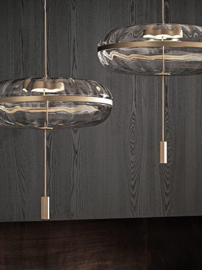 Two Jolie pendants against a dark wall
