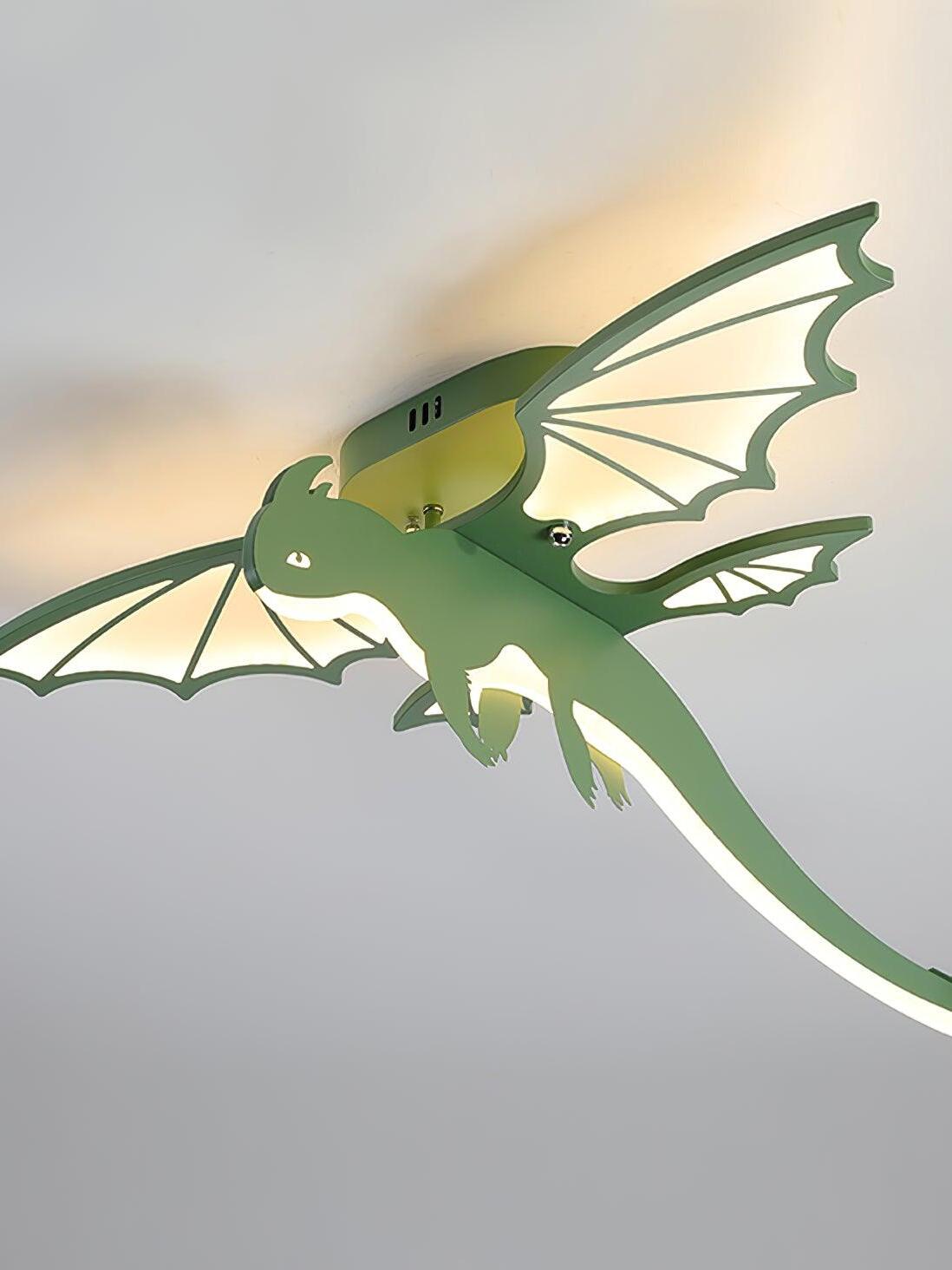 Lit green wings and long tail on ceiling fixture