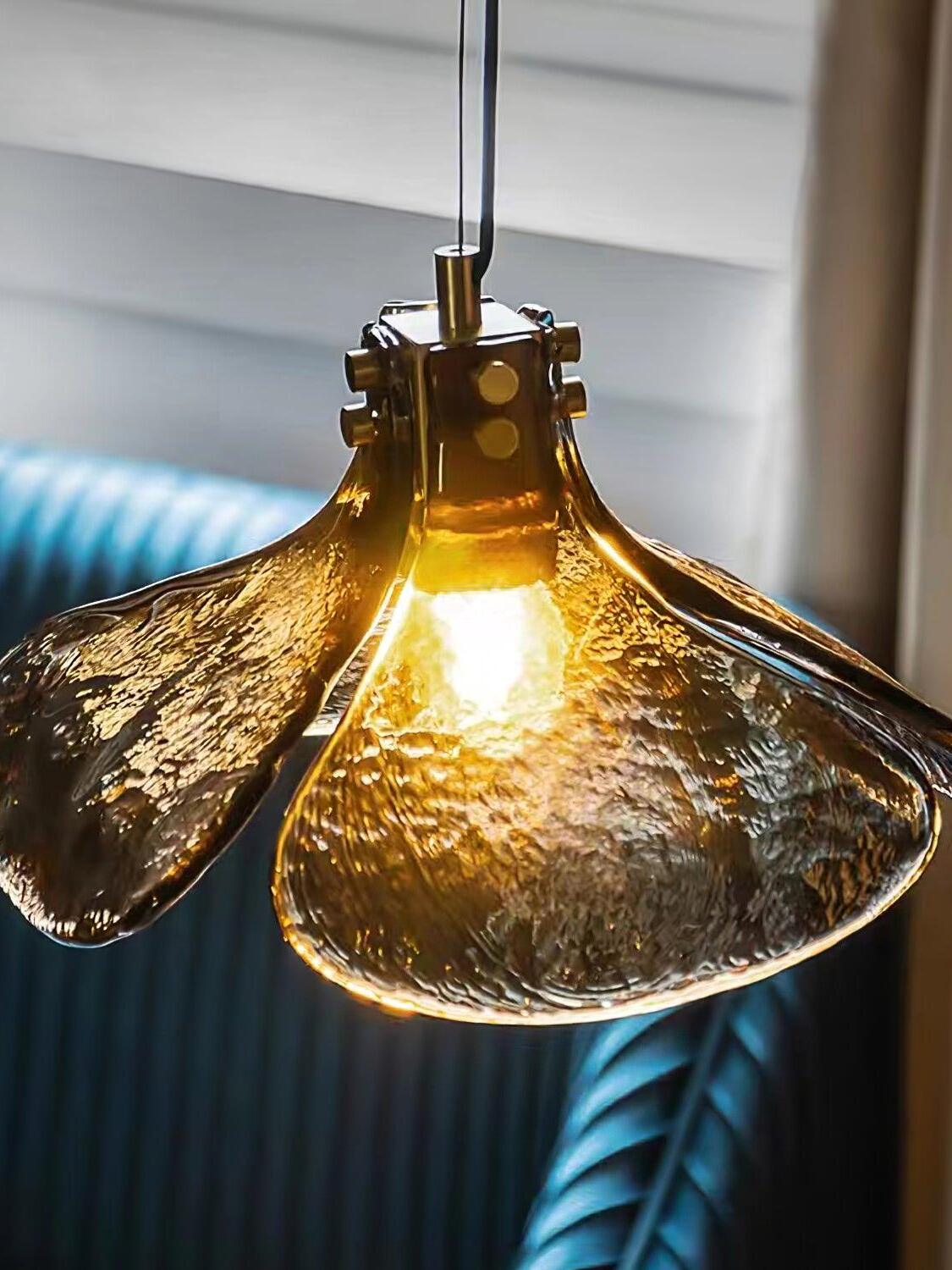 Textured brown glass pendant glowing near blue seating