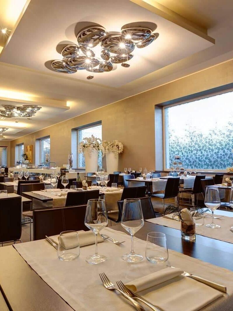 Reflective ceiling clusters along restaurant tables beside large windows