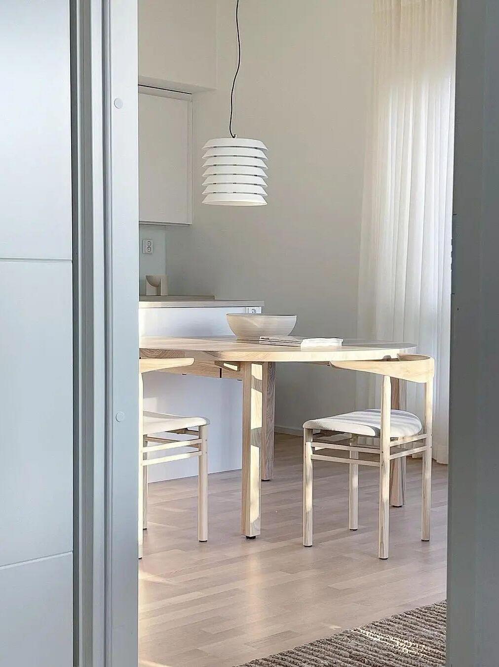 White layered pendant in bright dining room viewed through doorway