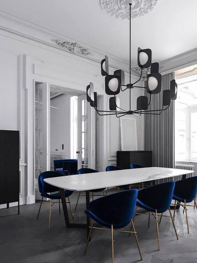 Tiered black LEAF chandelier above a dining table