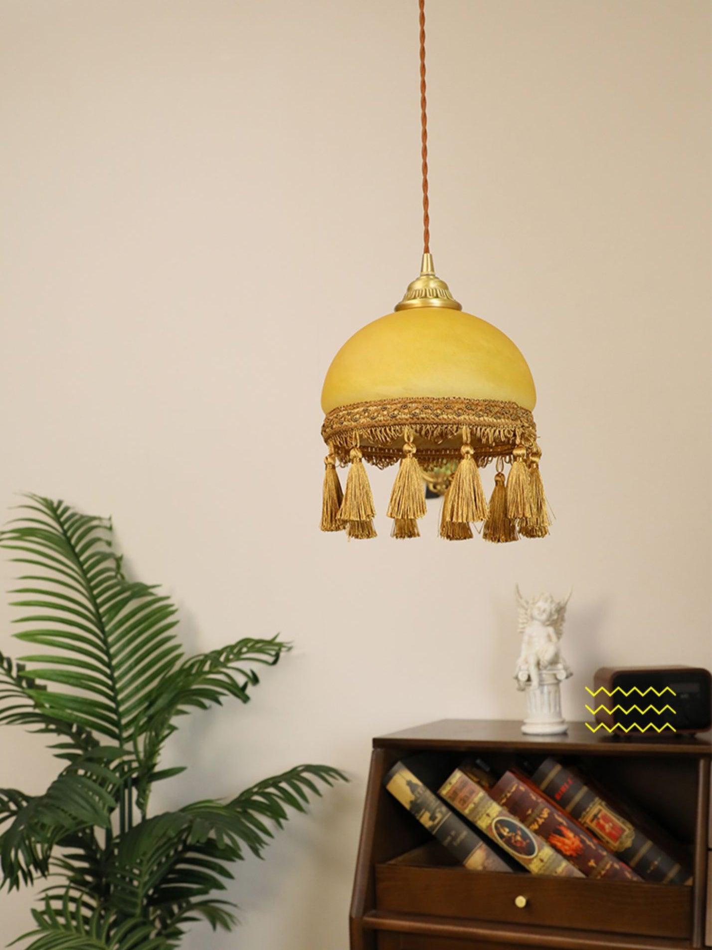 Single tassel pendant near plant and low cabinet