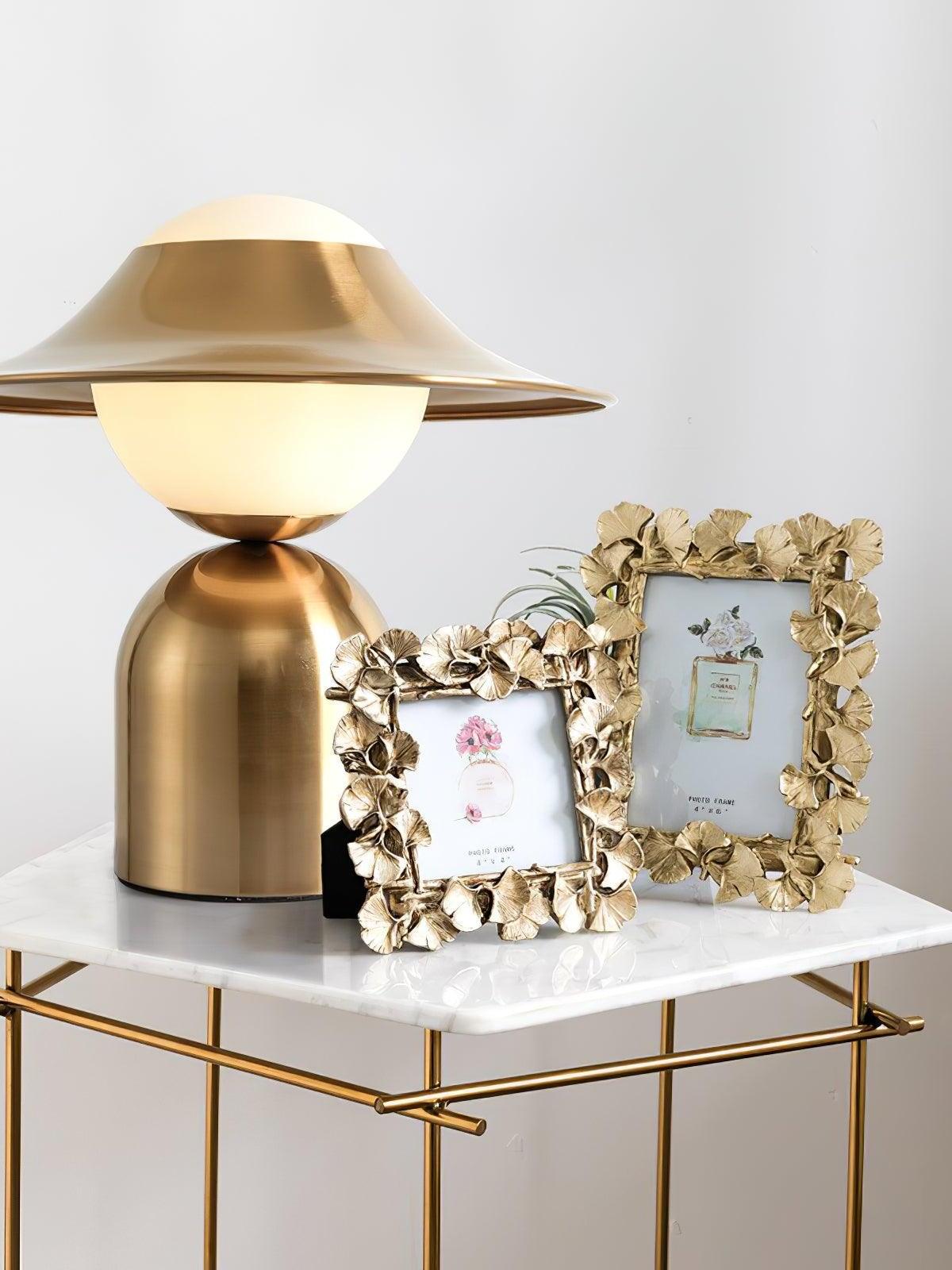 Gold and white globe lamp beside framed photos
