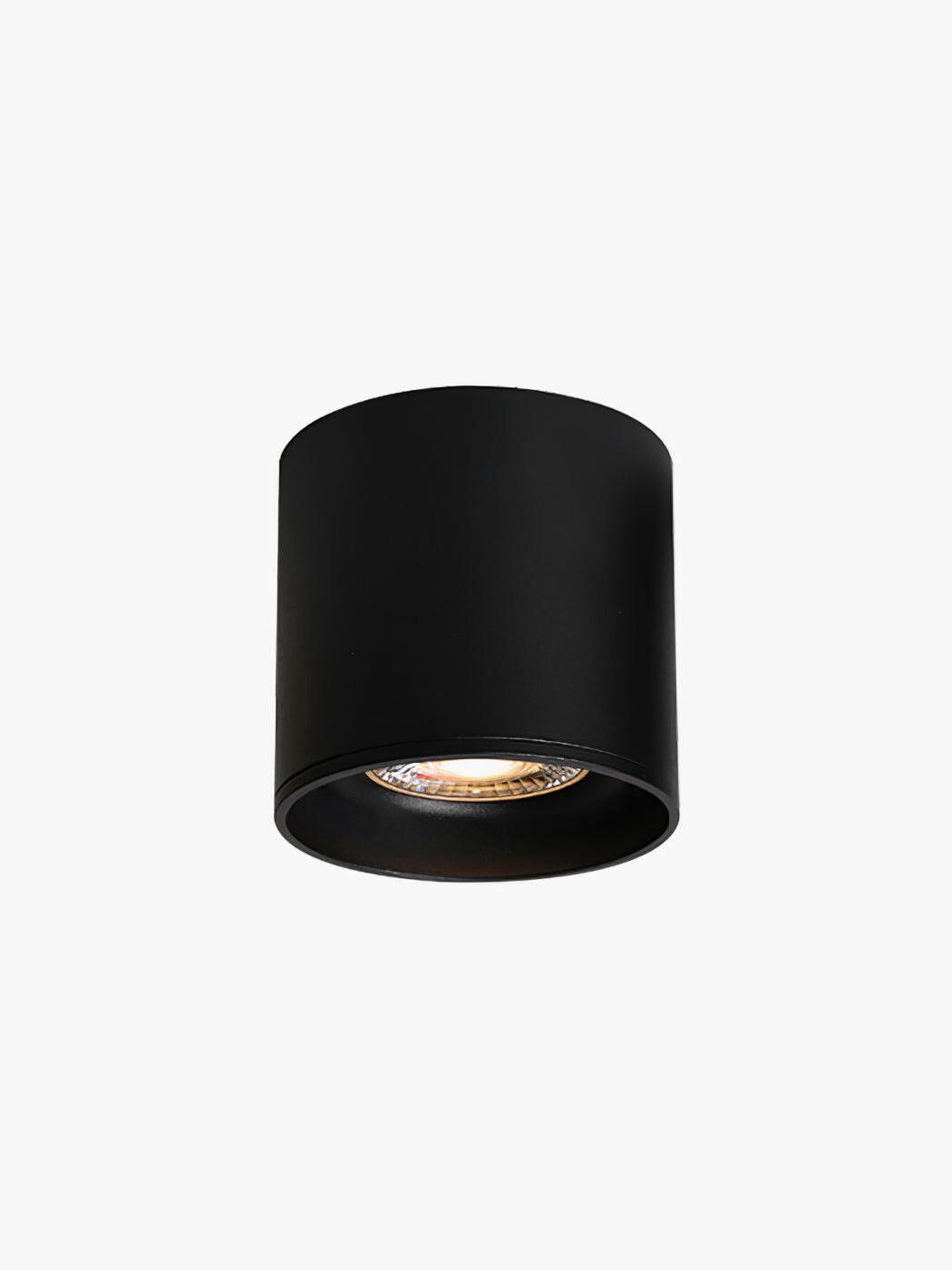 Black Modupoint cylinder on pale background with illuminated circular optic inset inside the deep lower rim