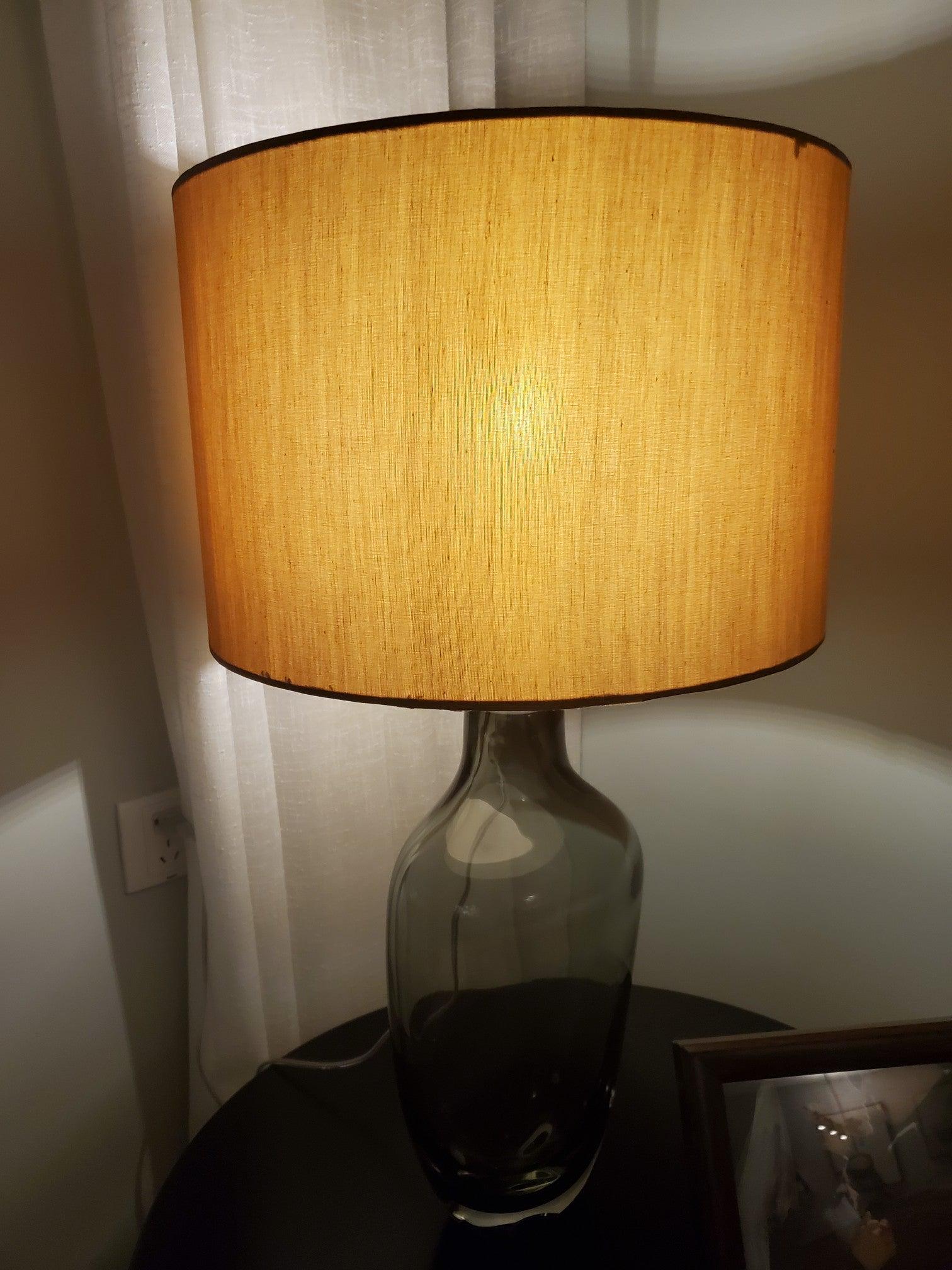 Illuminated textured drum shade above translucent smoky base