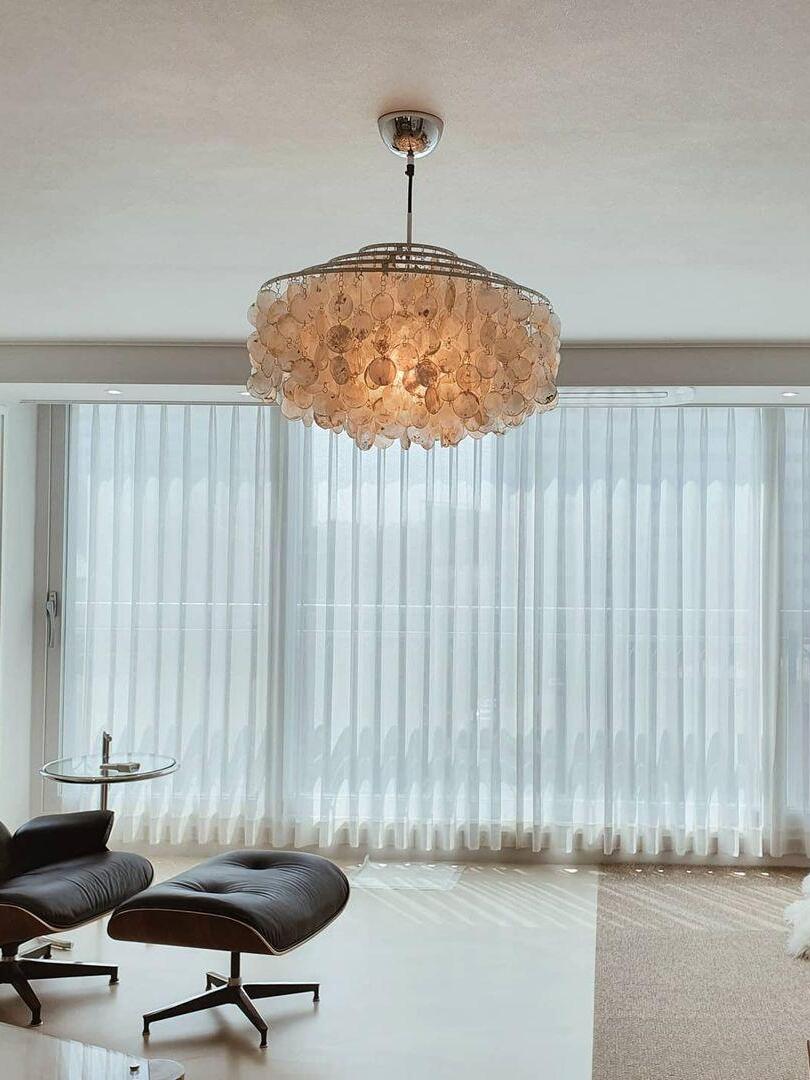 Warm-looking round shell fixture near curtains