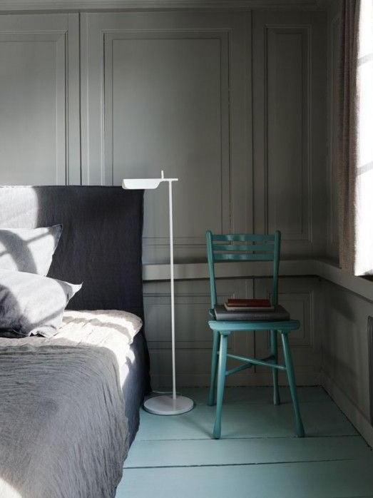 White floor lamp beside a bed