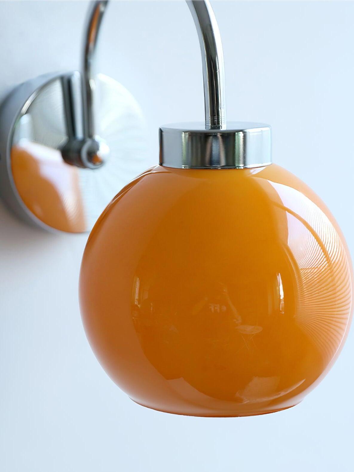 Close orange glass globe with silver-tone cap and reflected room shapes