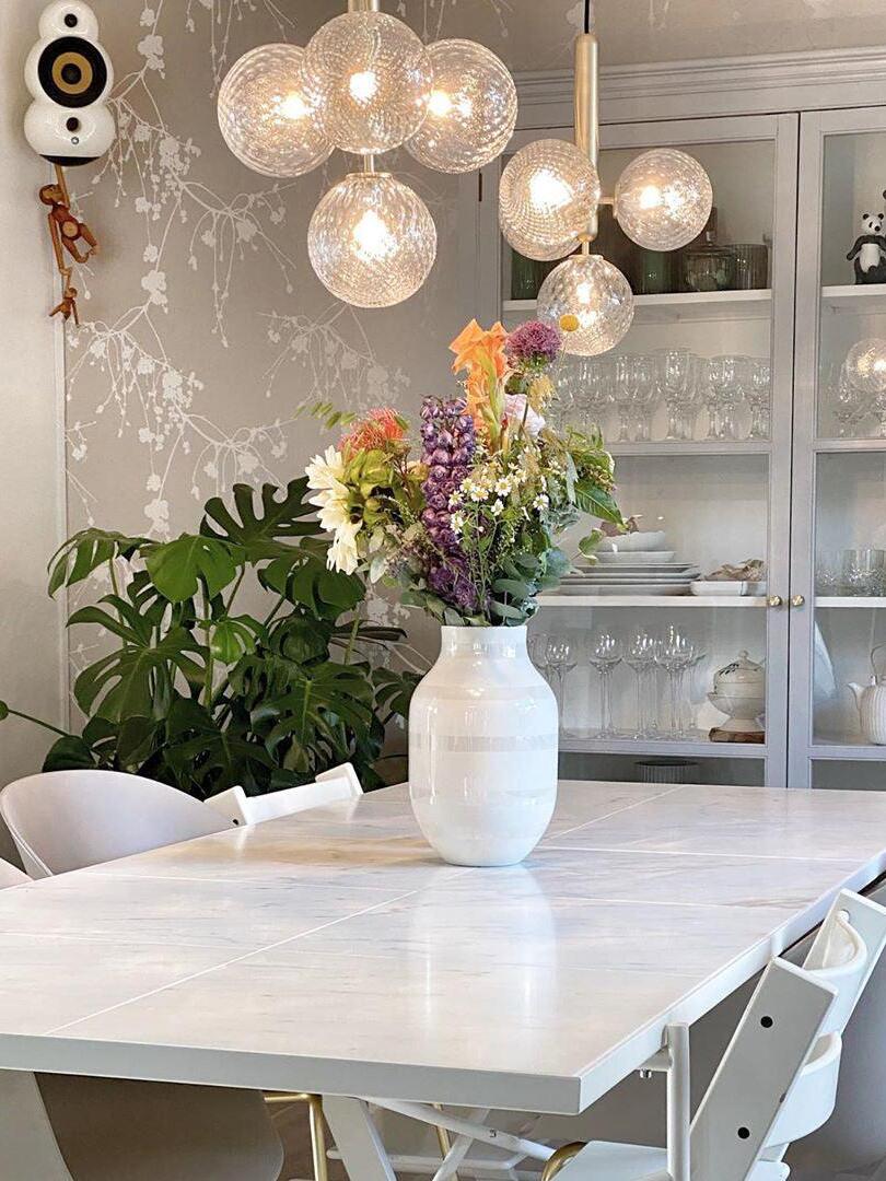 Clear glass globe cluster above a flower-filled table
