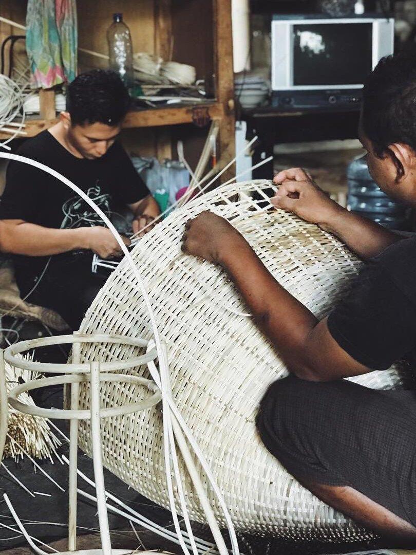 Hands weaving a rounded natural-colour shade