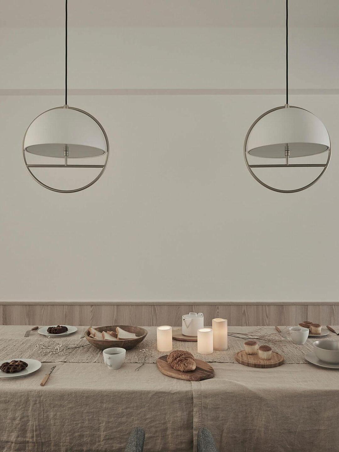 Two white ring pendants styled above dining table
