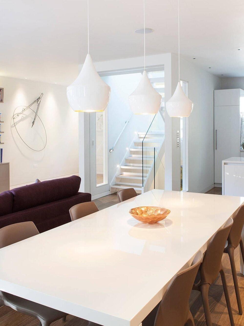 White pendants above a long dining table