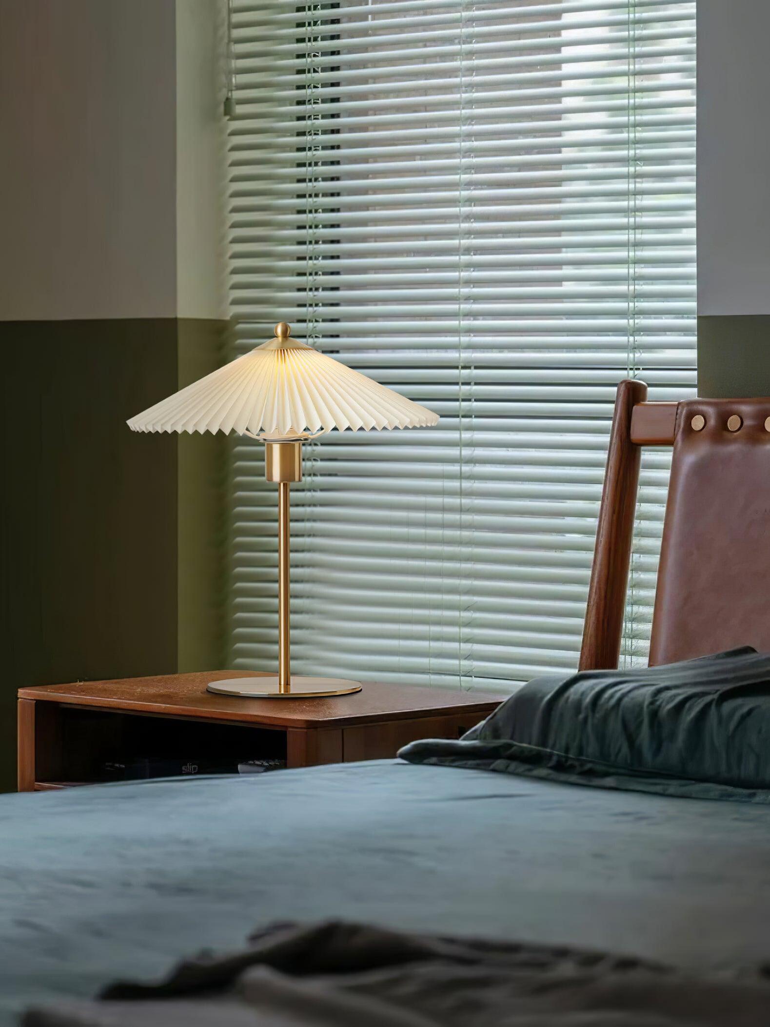 Perla table lamp on a wooden bedside cabinet near window blinds and dark bedding