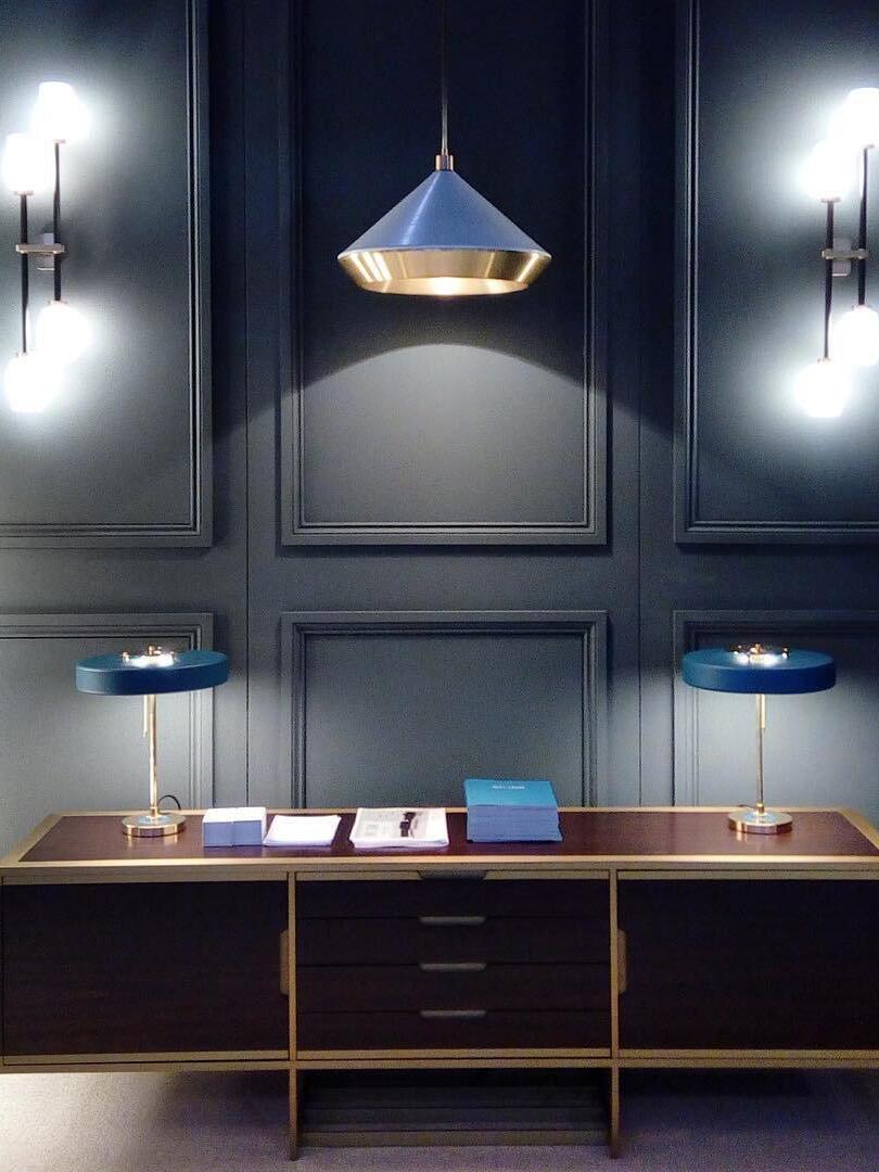 Black conical pendant over a dark vanity area
