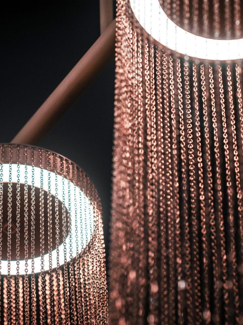 Two bright rings behind fine rose-gold chains