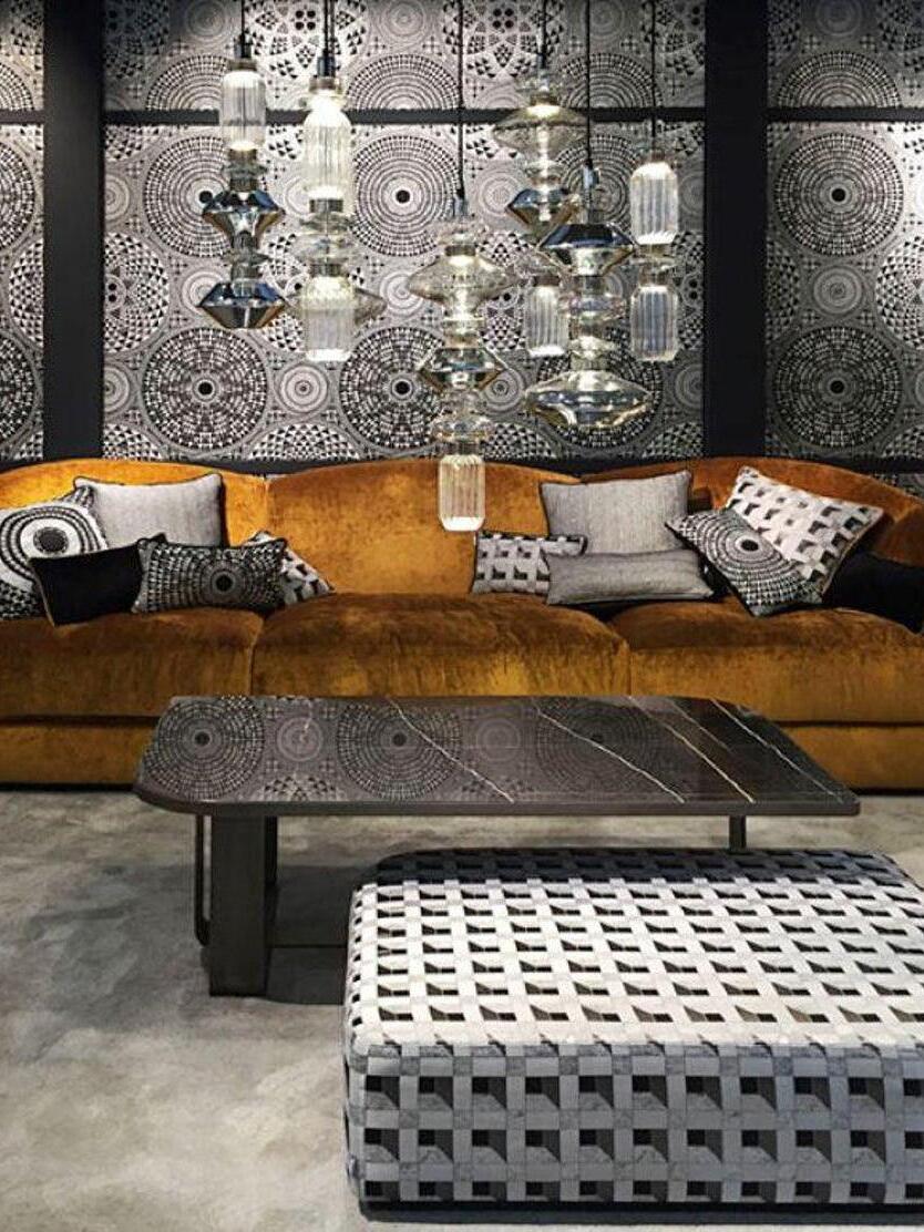Dense group of clear and smoky glass pendants over a sofa