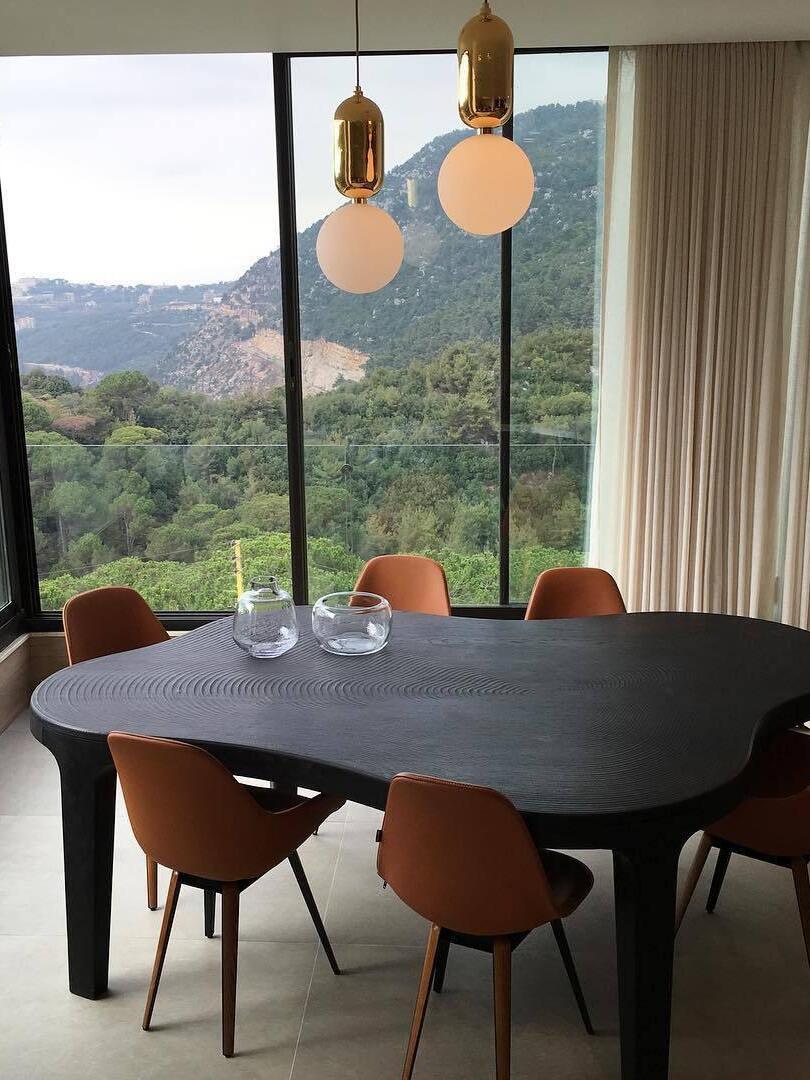 White globe pendants beside a window over a dining table