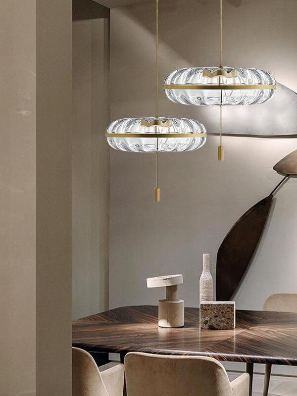 Two clear glass pendants above a table