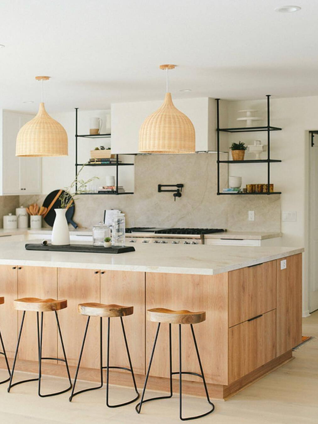 Two woven bell pendants above a kitchen island